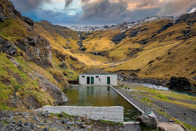 Malerischer Seljavallalaug geothermischer Hotspring-Pool gegen Berge bei Sonnenuntergang