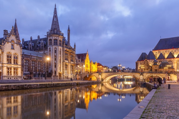 Malerisches mittelalterliches Gebäude und die St.-Michaels-Brücke am Kai Graslei im Fluss Leie in der Stadt Gent am Abend, Belgien