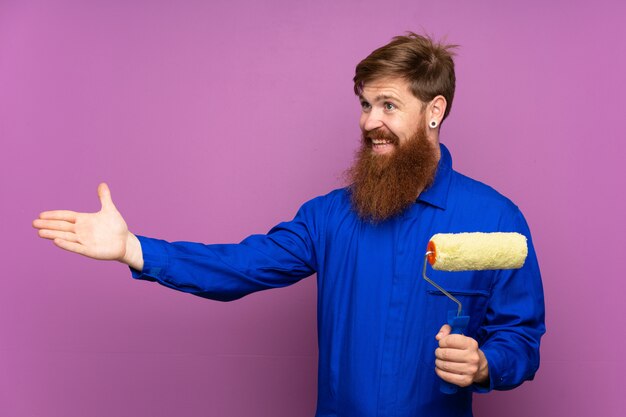 Malermann mit dem langen Bart, der Hände zur Seite für die Einladung ausdehnt zu kommen