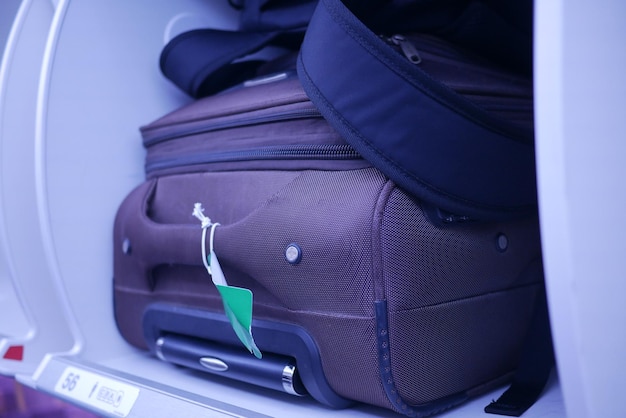 Maleta en un área de equipaje superior en la cabina de un avión