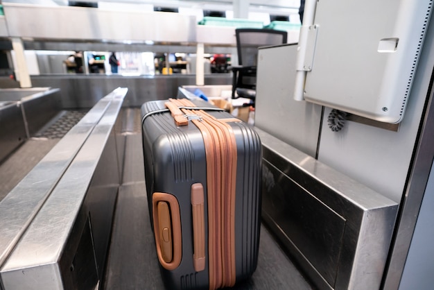 Maleta en el sistema de cinta transportadora de equipaje en el mostrador de facturación en el aeropuerto