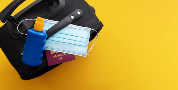 Maleta de viaje covid con mascarilla solar crema y pasaporte