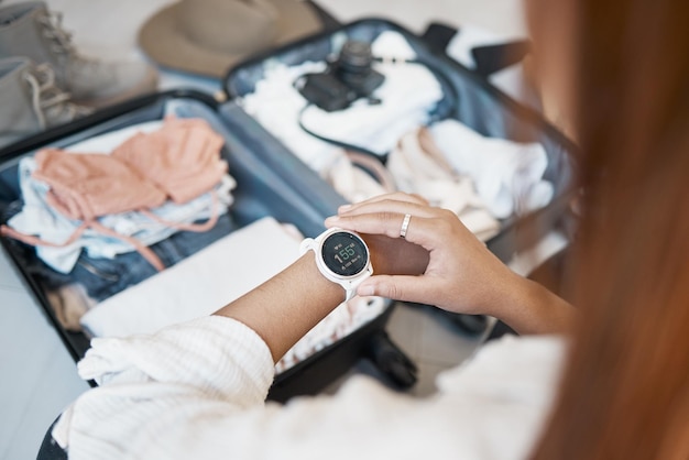 Maleta de viaje y reloj con manos de mujer para planificar vacaciones y empacar ropa Equipaje de viaje y aventura con viajero y reloj en casa para turismo de vacaciones y viaje al extranjero