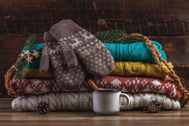 Malha, blusas de inverno, luvas quentes e uma caneca de chocolate quente. roupas de inverno.