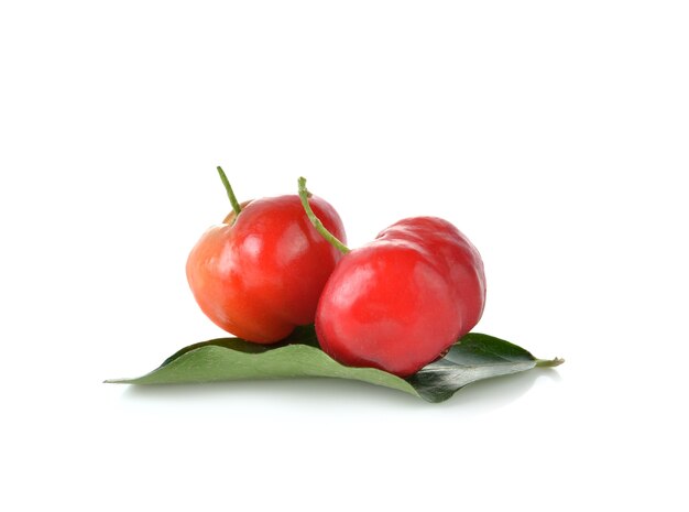 Malpighia glabra, acerola fruta sobre pared blanca