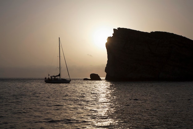 Malta, Insel Gozo, Blick auf die felsige Küste der Insel bei Dwejra und ein Segelboot