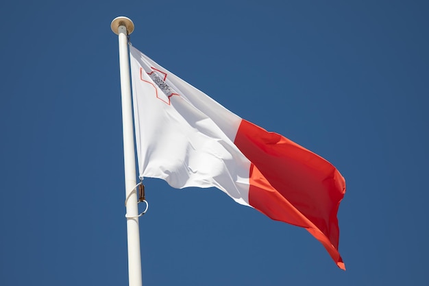 Maltesische Flagge rot-weiß Land auf dem Mast im Wind und blauen Himmel