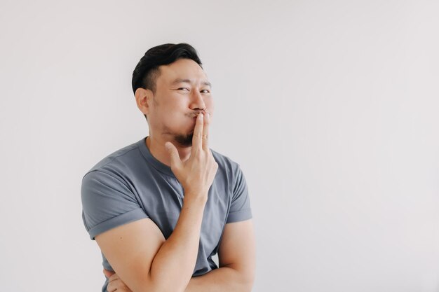 Foto las malvadas miradas del hombre con la camiseta azul sonríen y sonríen aislados en el blanco