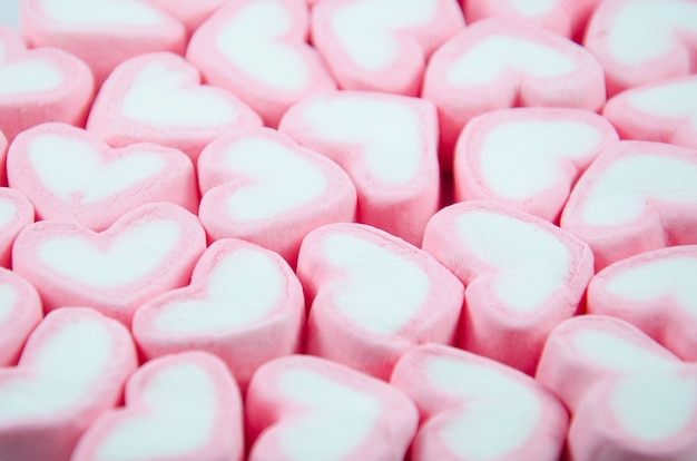 Malvavisco rosa en forma de corazón apilada en la mesa de madera azul