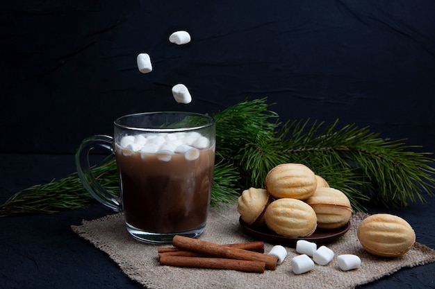 Malvaviscos cae en taza de vidrio con bebida de chocolate caliente con cacao. Concepto de comida y bebida de invierno. Malvavisco volador.