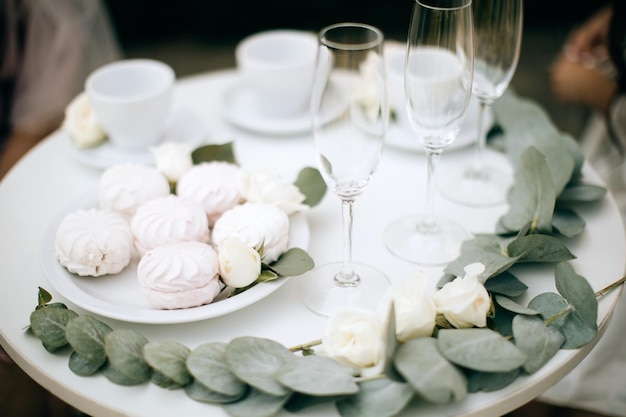 Malvaviscos y copas de champán en una mesa blanca Decoración de bodas