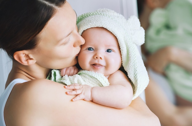 Foto mamá abraza a su pequeño bebé más lindo después del baño con una toalla en la cabeza vida familiar madre y bebé