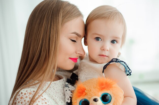 Mamá abrazando y besando a su pequeña hija.