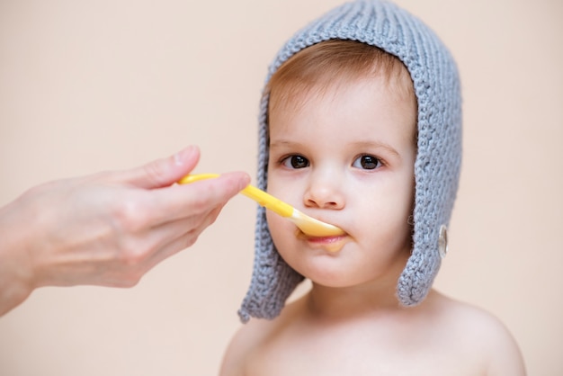 Mamá alimenta al bebé con puré de frutas