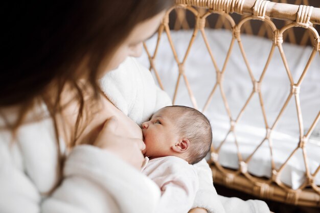 Mamá amorosa acariciando a su bebé recién nacido bebé comiendo leche materna