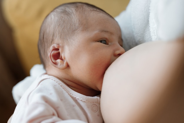 Mamá amorosa acariciando a su bebé recién nacido bebé comiendo leche materna