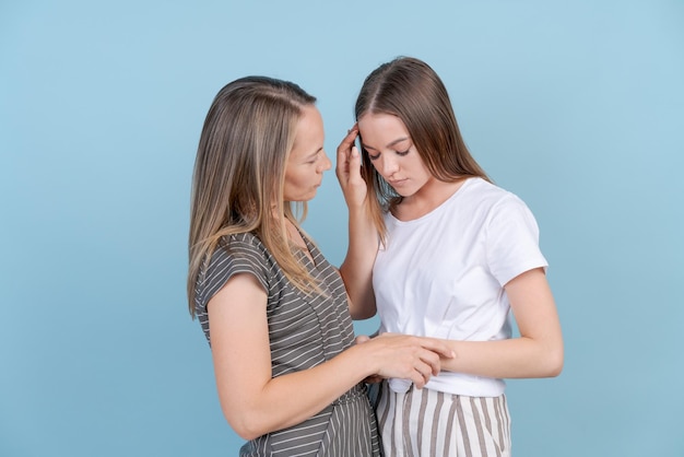 Mamá apoya a una hija moralmente adulta y triste que tiene problemas de fondo azul