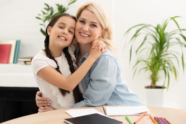 Mamá ayudando a su hija a hacer la tarea.