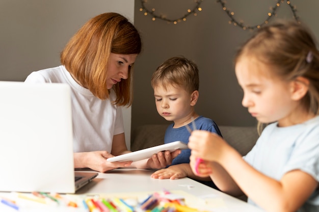 Mamá ayudando a sus hijos a hacer sus deberes