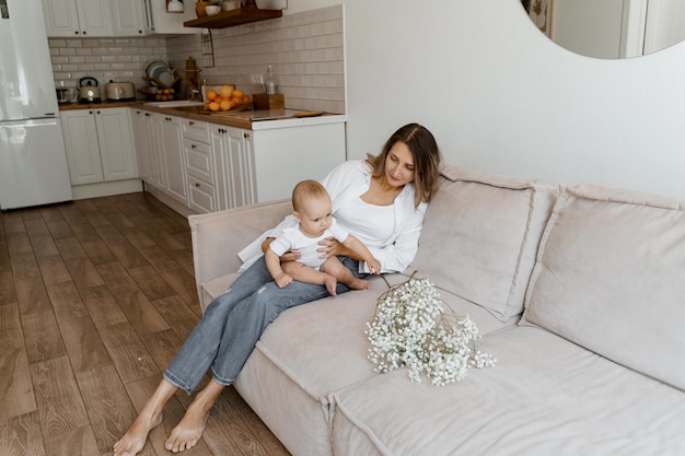 mamá y bebé en la cama con un ramo de flores blancas