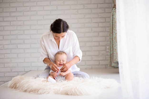 Mamá y bebé jugando en el dormitorio