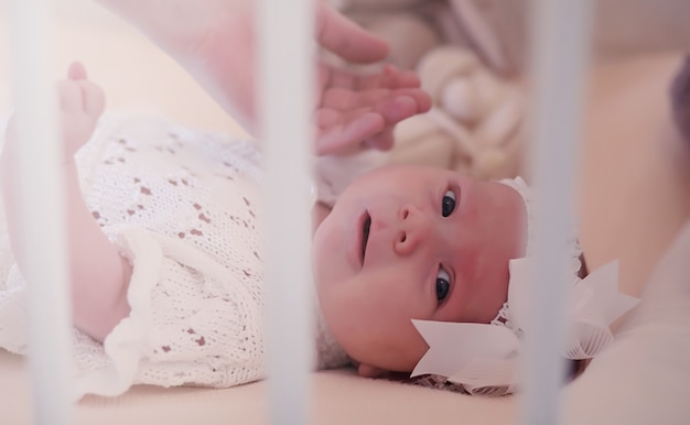 Foto mamá con un bebé recién nacido en brazos. la niña sostiene a un bebé frente a la ventana. recién nacido en manos de la madre.