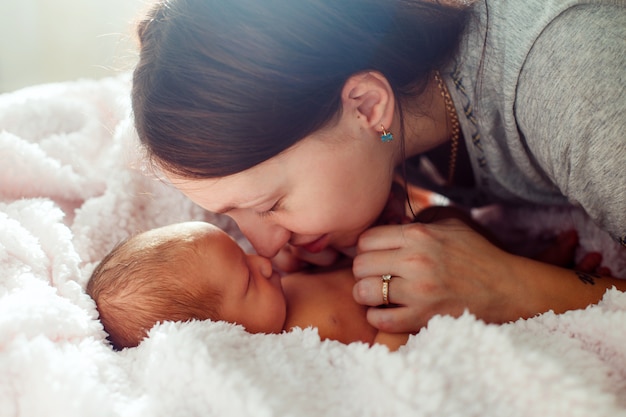 Mamá y bebé recién nacido en la pared blanca