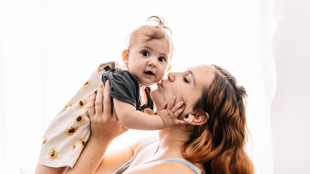 Foto mamá besando al bebé en la mejilla