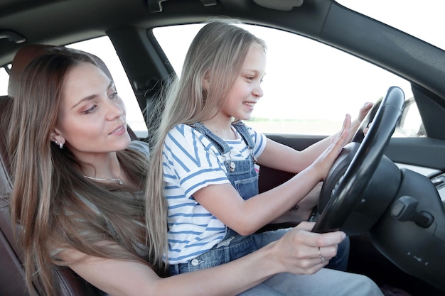 Mama bringt ihrer kleinen Tochter das Autofahren bei