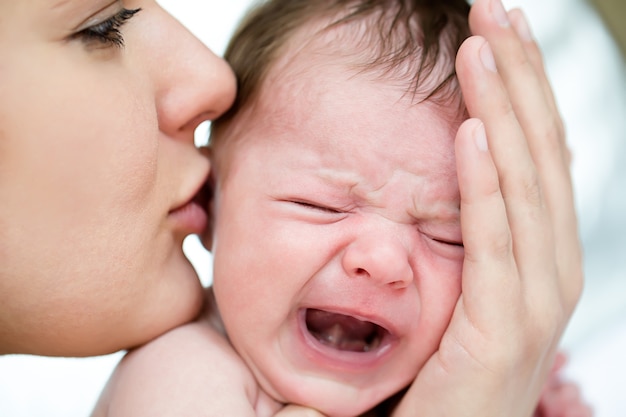 Mamá calma a un bebé que llora