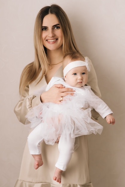 Mamá cariñosa que cuida de su bebé recién nacido en casa. Brillante retrato de mamá feliz con niño durmiendo en las manos. Madre abrazando a su pequeño hijo de 4 meses.