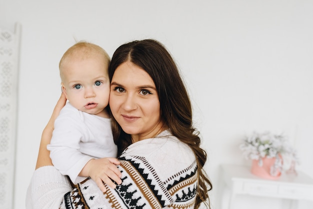 Mamá caucásica joven sosteniendo a su bebé