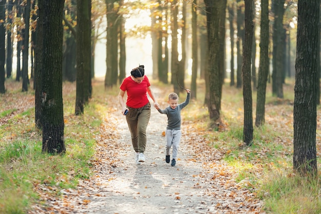 Mamá corre con su hijo en el parque