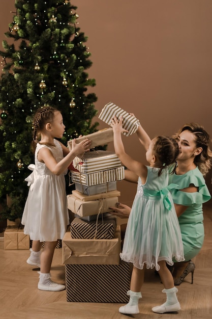 Foto mamá les da regalos a sus hijas para navidad