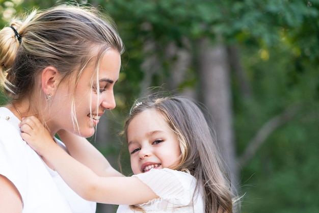 Mamá e hija abrazan a la familia feliz y la encantadora mamá e hija pasan tiempo juntas el día de la madre fa ...