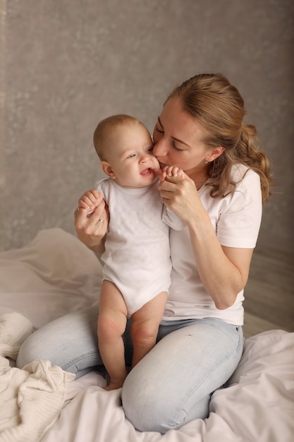 mamá e hija se abrazan en una sábana blanca maternidad