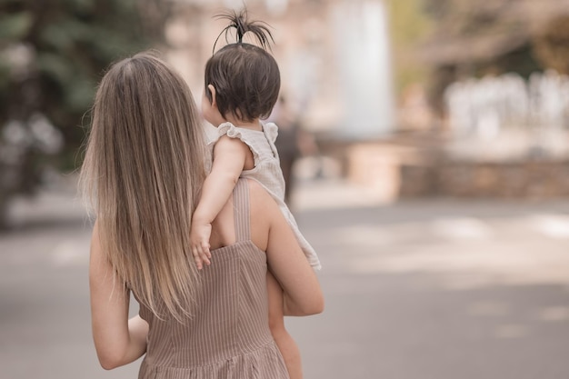 Foto mamá e hija en la calle en el verano en la ciudad caminando en el parque