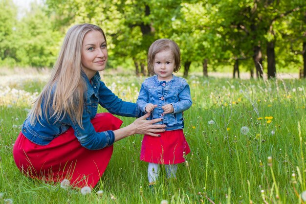 Mamá e hija caminan por el bosque con la misma ropa.