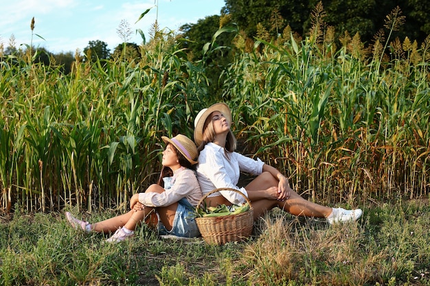 Foto mamá e hija en un campo de maíz