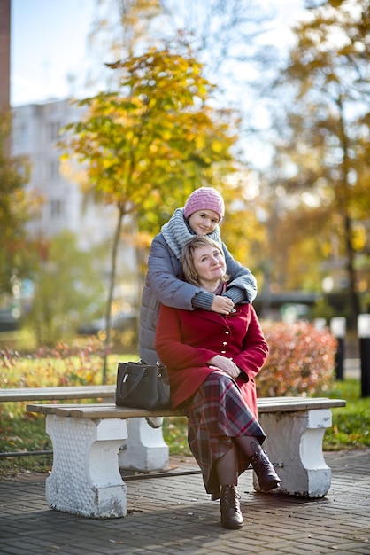 Mamá e hija en la ciudad de otoño.