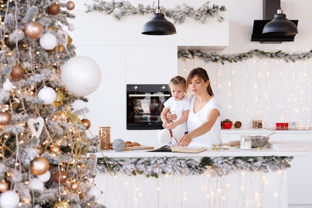 Mamá e hija en la cocina de casa en el año nuevo.