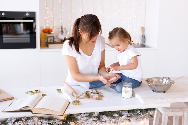 Mamá e hija cocinan galletas en Navidad