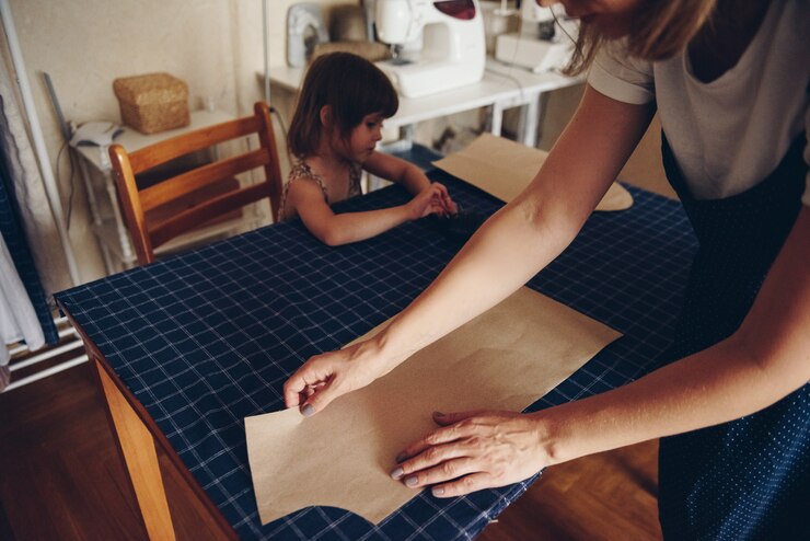 Foto mamá e hija cosen ropa juntas. vestido estampado.