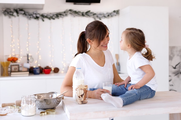 Mamá e hija se divierten y cocinan en la cocina de casa en el nuevo año.