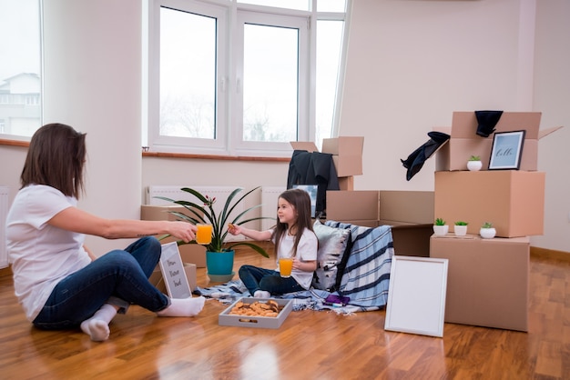 Foto mamá e hija se divierten por mudarse en el copyspace del apartamento ne