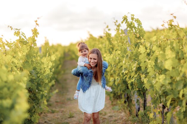 mamá e hija divirtiéndose en el viñedo