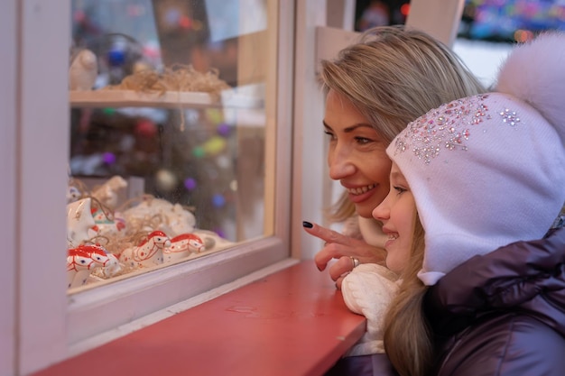 Mamá e hija eligen comprar recuerdos en el mercado navideño