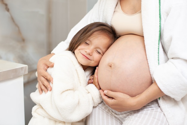 Mamá e hija embarazadas por la mañana en el baño