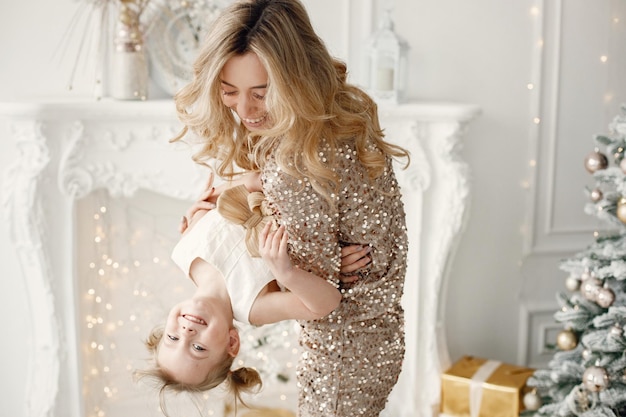 Mamá e hija jugando juntas en sudio blanco