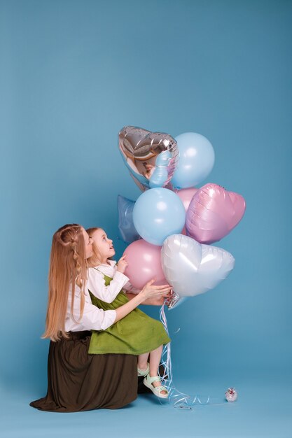 Mamá e hija con un montón de globos en el día de la madre.